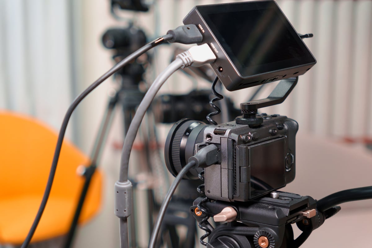 Professional video camera and monitors on tripod in broadcast studio setup